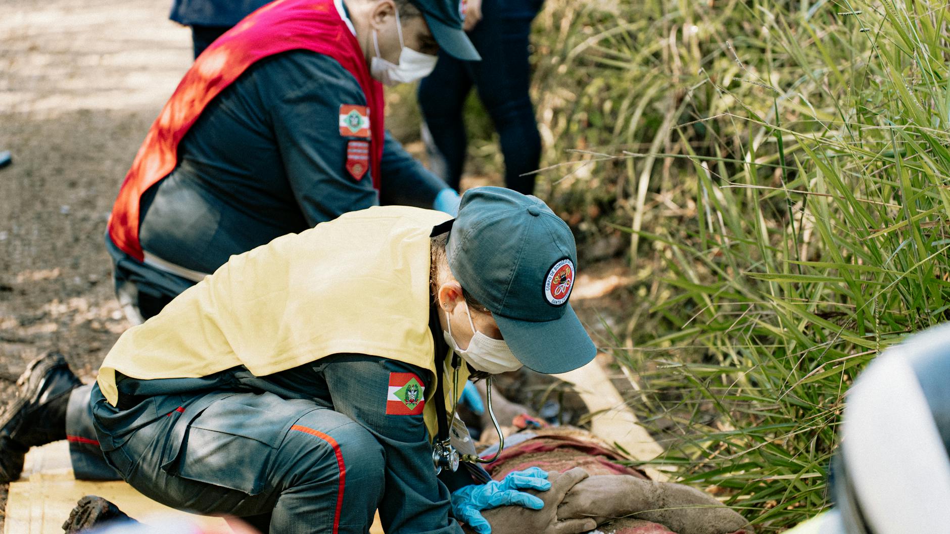 Emergency responders perform a life-saving simulation outdoors, demonstrating teamwork and first aid skills.