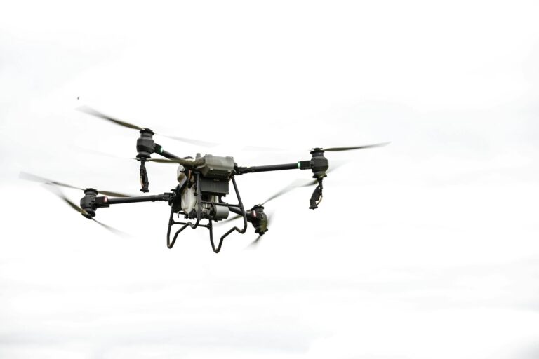 Slankt, egenbygd FPV-racerdrone med karbonfiber-ramme på bakken i ørkenlignende terreng.