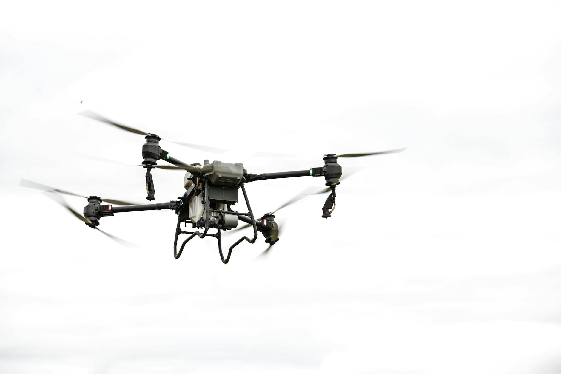 Slankt, egenbygd FPV-racerdrone med karbonfiber-ramme på bakken i ørkenlignende terreng.