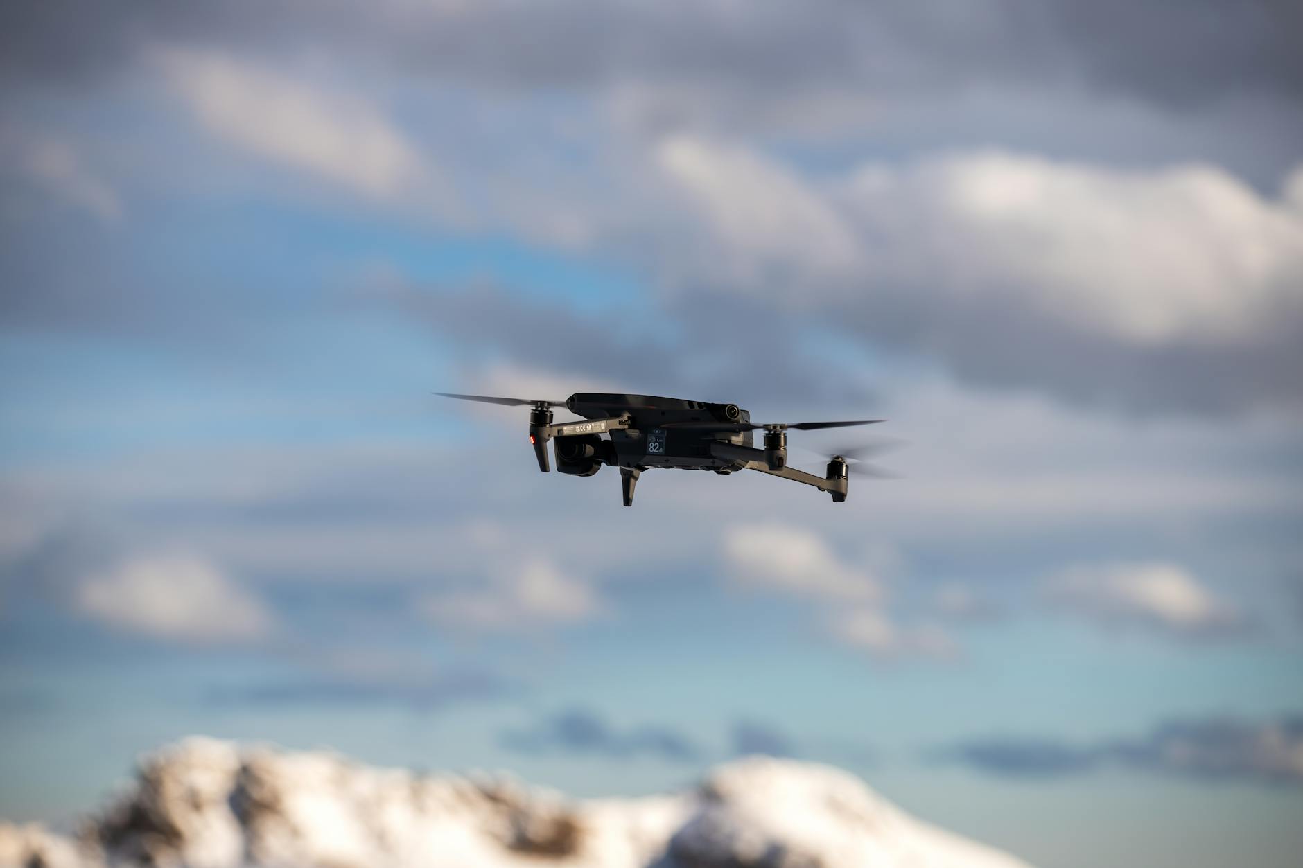 Person med drone-kontroller foran laptop med kursmateriell på skjermen, studerer droneregler.