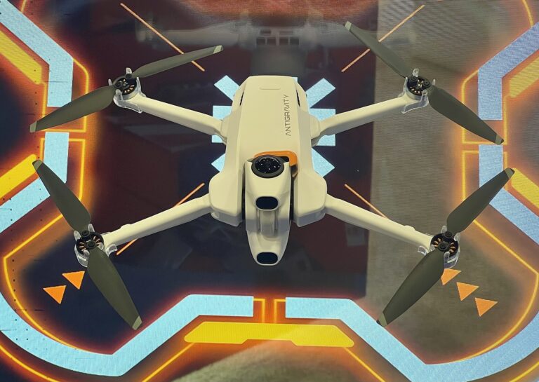 Antigravity A1 hvit FPV-drone i lufta over opplyst landingsplattform