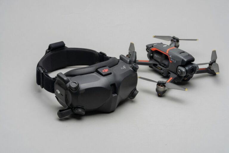 DJI FPV-briller plassert ved siden av en sammenleggbar drone på et nøytralt underlag
