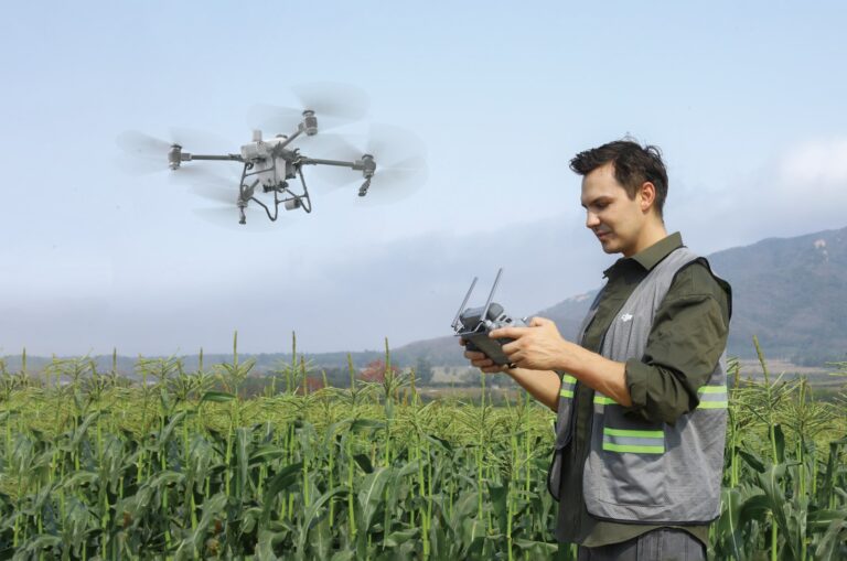 DJI Agras jordbruksdrone i lufta over en åker med operatør