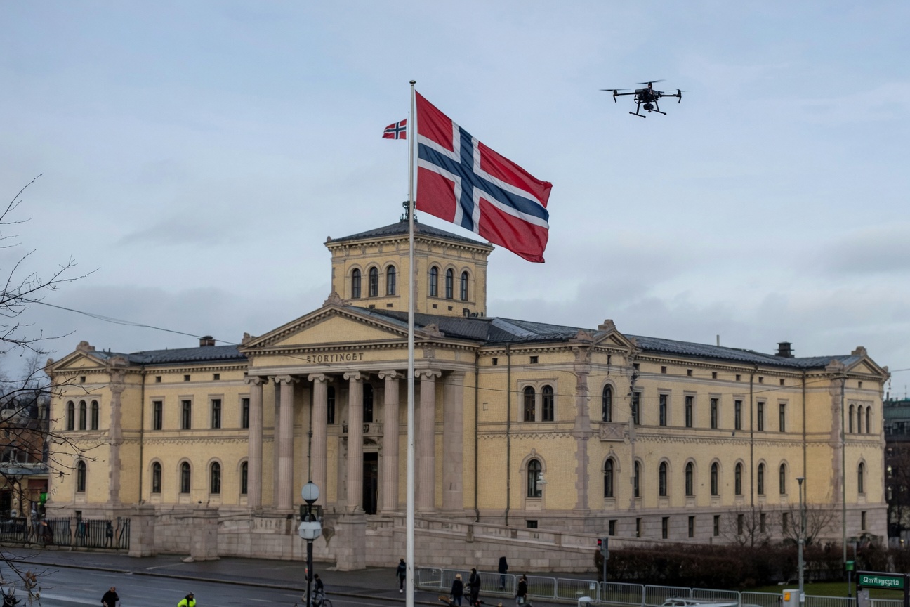 Stortingsbygningen i Oslo sett utenfra, med norsk flagg i forgrunnen.