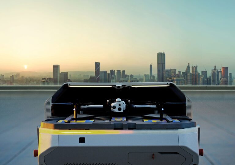 Skydio-drone i autonom dockingstasjon med byhimmel i bakgrunnen