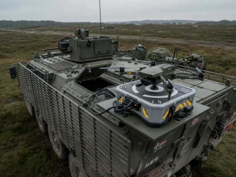 Militær mikrodrone montert på dokk på toppen av et taktisk kjøretøy i felt