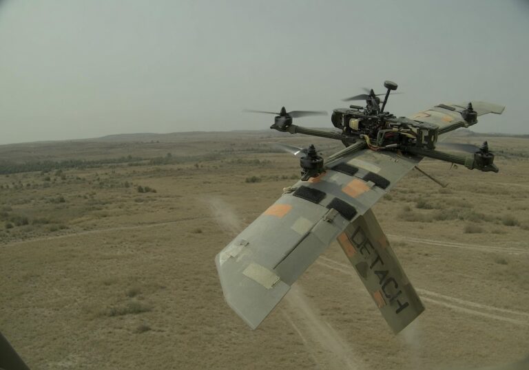 Ukrainsk FPV-drone med avtakbar vinge i flukt over åpent landskap.