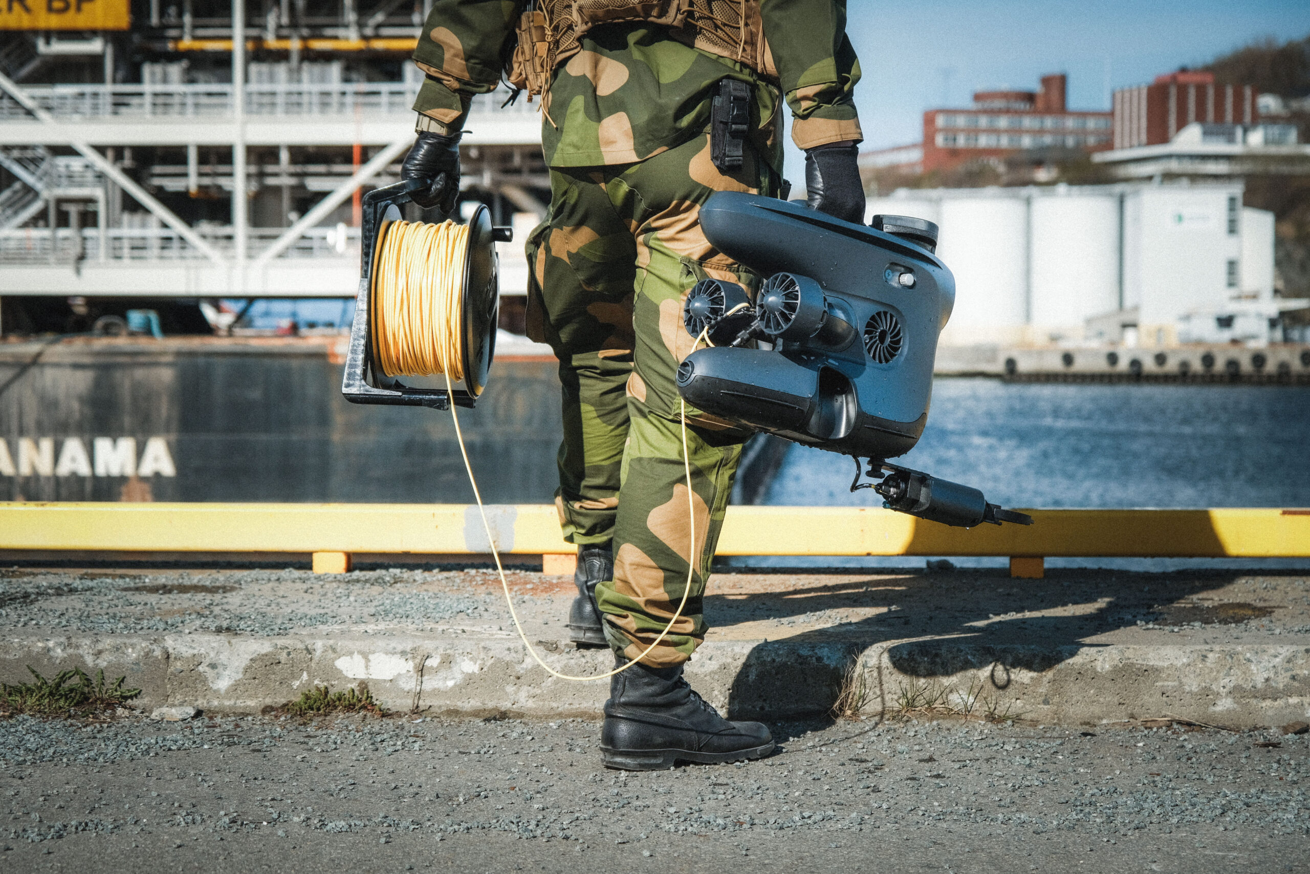 Blå undervannsdrone av typen mini-ROV under vann med kamera og LED-lys synlig.