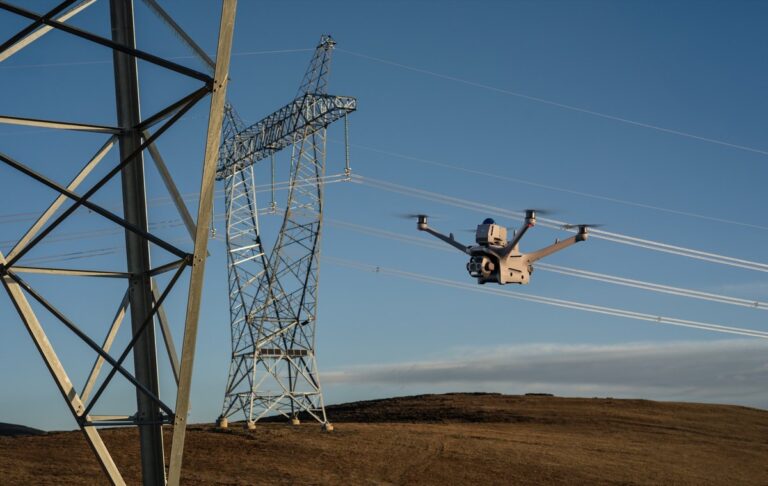 DJI Matrice 4D i flukt ved en høyspentmast, med hindersensormodulen synlig på toppen