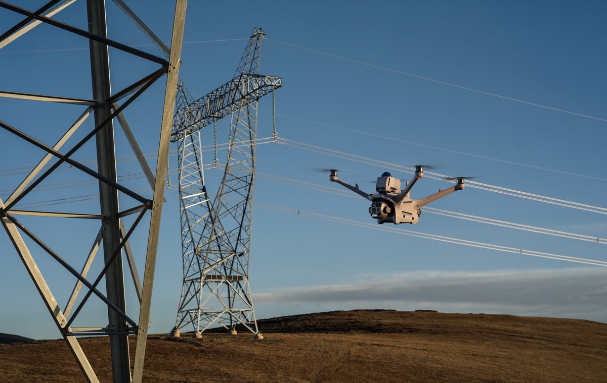 DJI Matrice 4D i flukt ved en høyspentmast, med hindersensormodulen synlig på toppen