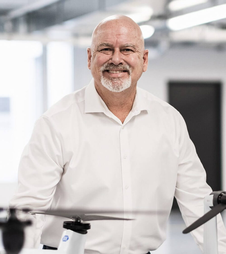 VTOL-drone med fast vinge og elektrisk motor plassert på gresslette, klar for start.