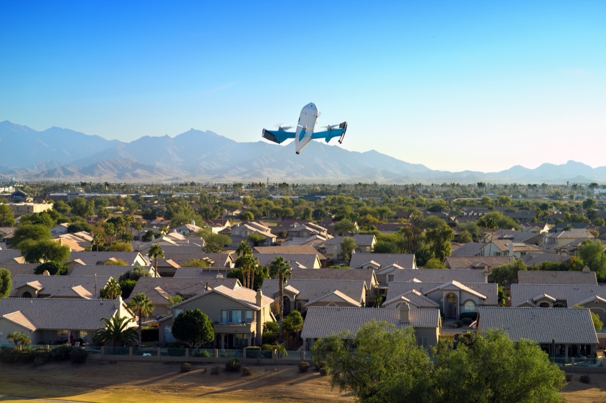Amazon Prime Air MK30-leveringsdrone i lufta over et amerikansk boligområde med fjell i bakgrunnen