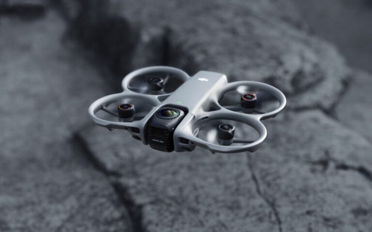 360-graders FPV-drone med to kameralinser holdt frem i hånden, med redigeringsskjerm i bakgrunnen