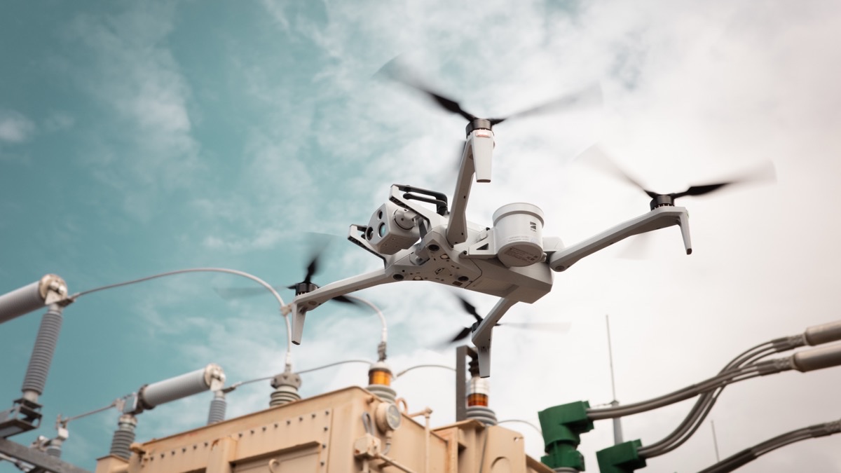 Skydio X10-drone flyr tett inntil utstyr i en transformatorstasjon under inspeksjon