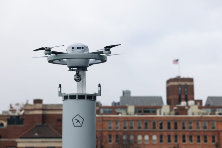 Birdstops sensordrone Fealty står på toppen av dokkingstasjonen, med murbygninger i bakgrunnen
