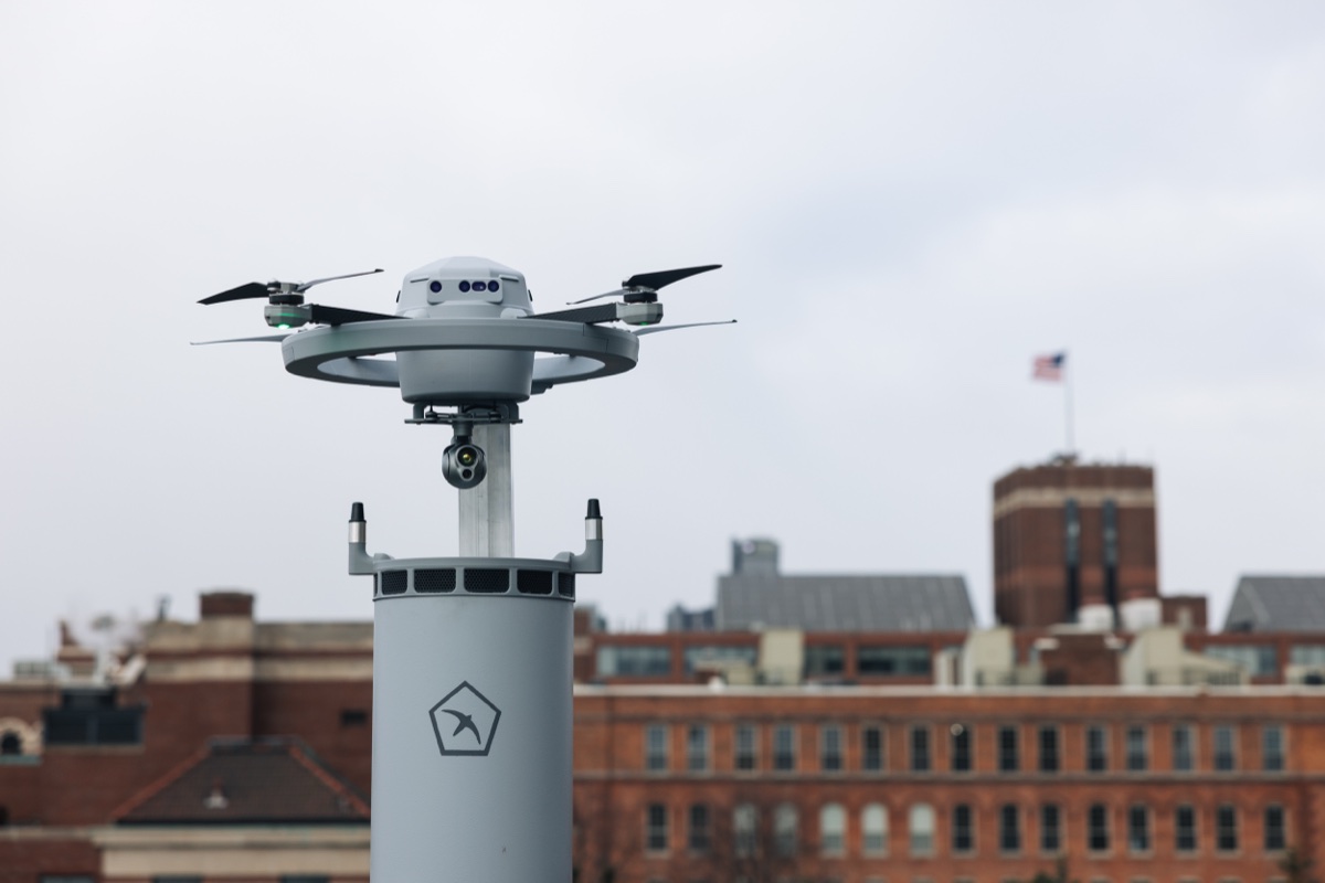 Birdstops sensordrone Fealty står på toppen av dokkingstasjonen, med murbygninger i bakgrunnen