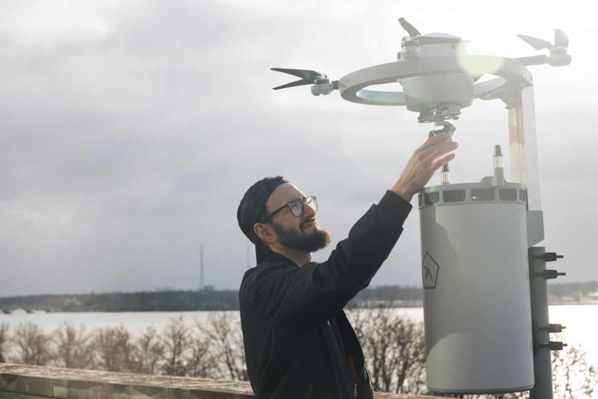En person setter Birdstops drone Fealty på plass på dokkingstasjonen ved en elv