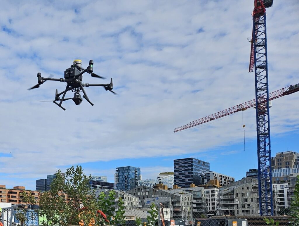 En DJI Matrice 300 i lufta over en byggeplass med kran og boligblokker i Oslo