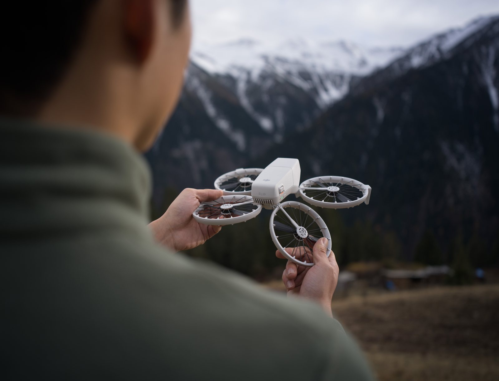DJI Flip holdes i to hender med sammenleggbart propellvern rundt alle fire propellene