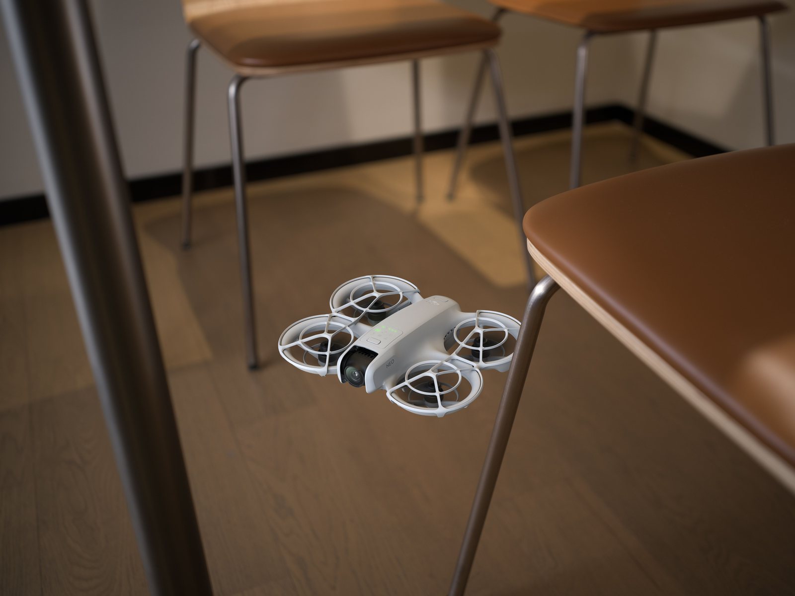 DJI Neo med propellvern flyr lavt innendørs mellom stoler